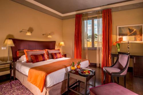a hotel room with a large bed and a chair at The Inn at the Spanish Steps Luxury Collection - The Inn at the Spanish Steps in Rome