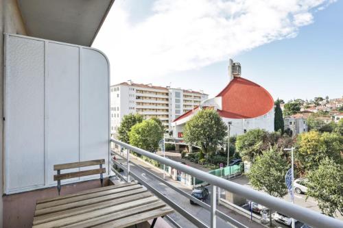 - un balcon avec un banc en bois sur une rue de la ville dans l'établissement Appartement Soleil d'Antibes - Welkeys, à Antibes