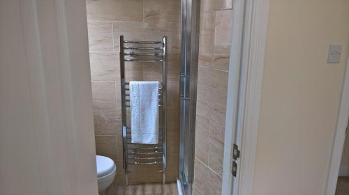 een badkamer met een douche, een toilet en een handdoek bij Cooks Row in Scarborough