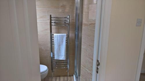 a bathroom with a shower with a toilet and a towel at Cooks Row in Scarborough