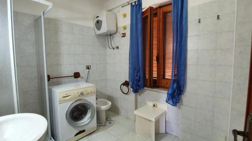 bagno con lavatrice e servizi igienici di EM Holiday Apartment a Quartu SantʼElena