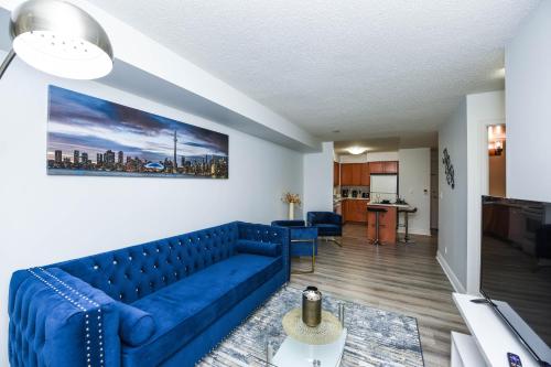 a living room with a blue couch and a kitchen at PlanURstay - Luxury 1BR Condo with City View in Mississauga