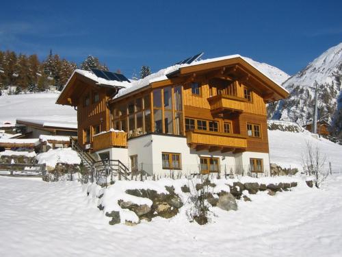 a large wooden house in the snow with snow at Appartementhaus Sonnleitn in Kals am Großglockner