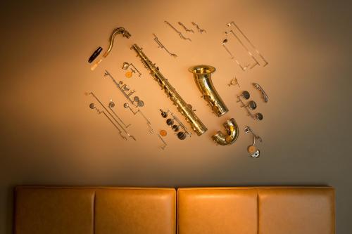 eine Gruppe von Saxophonen und Noten an einer Wand in der Unterkunft Hotel The Neufchatel in Brüssel
