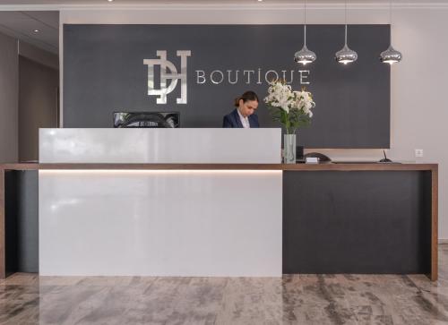 a woman standing at a reception desk in an office at Dore Boutique Hotel in Agia Marina Nea Kydonias