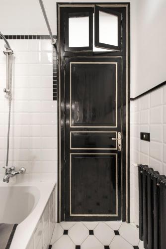 a black door in a white bathroom with a sink at Casa d'arte Ugdulena con Piscina e Terrazza by Wonderful Italy in Palermo