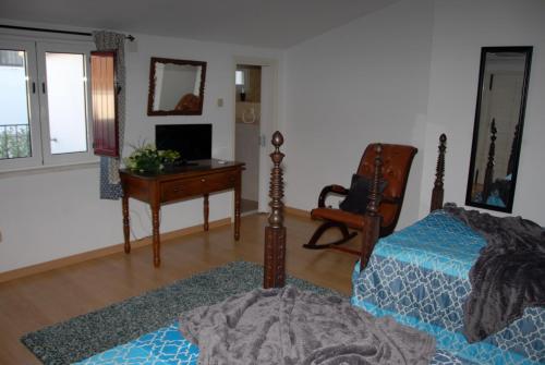 a bedroom with a bed and a desk and a chair at Casa do Coreto in Crato