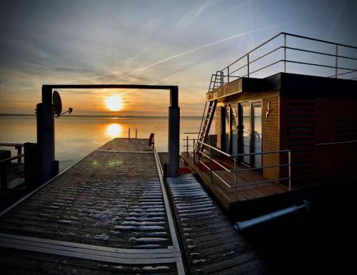 a sunset over a dock with a building on it at die Möwen in Vetschau