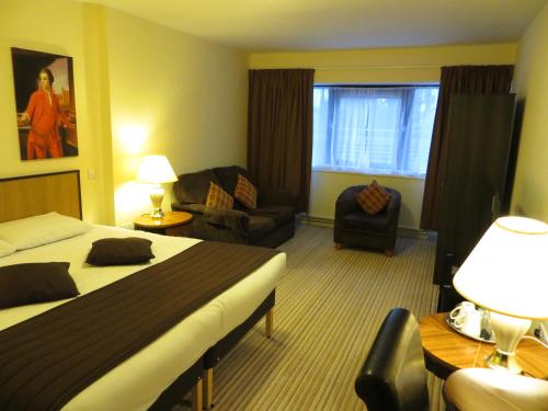 a hotel room with two beds and a chair at The Waterside in Peterhead
