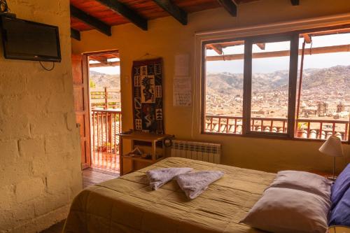 a bedroom with a bed with a view of a mountain at Samay Wasi Hostel I in Cusco