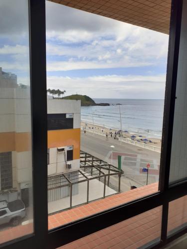 a view of the beach from a window at Farol Barra Flat in Salvador