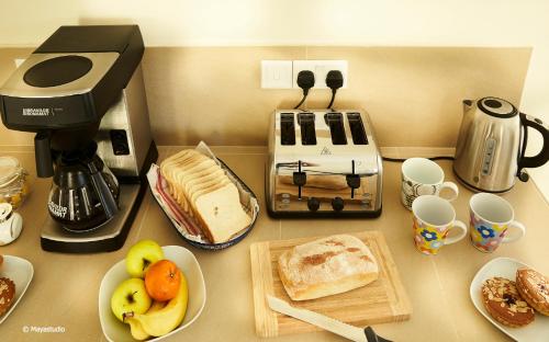 a counter top with a coffee maker and some food at Provicario in Victoria