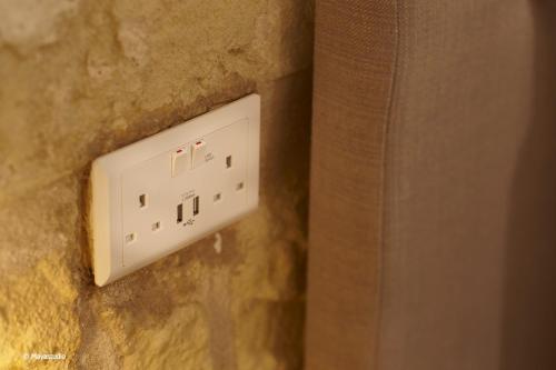 a white electrical outlet on a stone wall at Provicario in Victoria