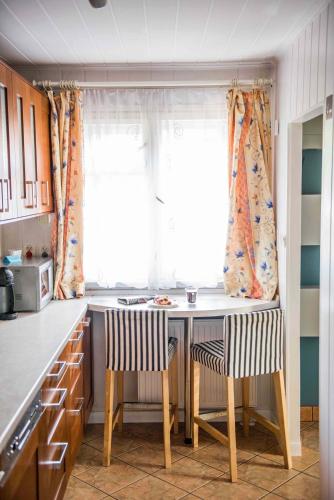 a kitchen with a table and chairs and a window at Domek w Dąbrowie in Wielogłowy