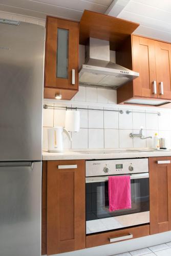 a kitchen with a stove and a refrigerator at Domek w Dąbrowie in Wielogłowy