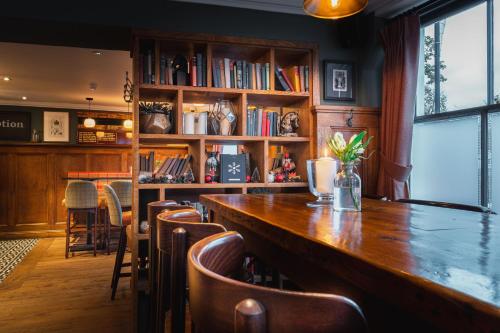 a bar with a long wooden table and chairs at Albert Arms in Esher