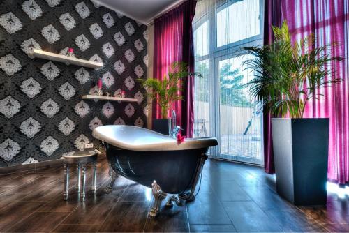 a bathroom with a tub and a potted plant at Hotel Woiński Spa in Lubniewice