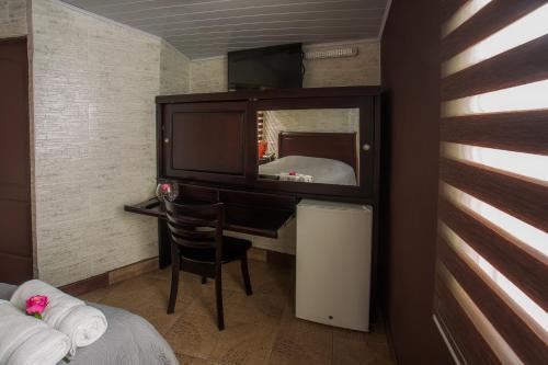 a bedroom with a vanity with a mirror and a desk at Boutique Hotel Casa Orquídeas in San José