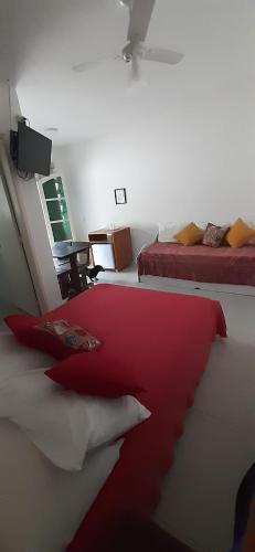a bedroom with two beds with red and white pillows at Suites Nativa in Ubatuba