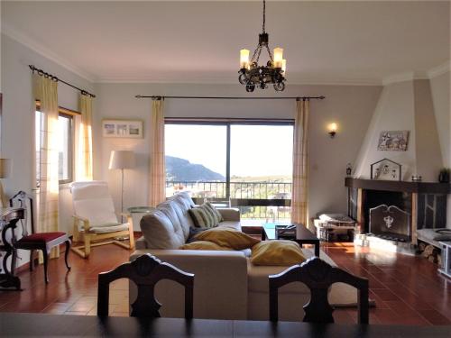 a living room with a couch and a large window at Casa do Mar in Santo Isidoro