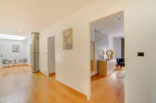 a living room with white walls and a wooden floor at Maison d'hôtes La Villa des Ducs Bar-le-Duc in Bar-le-Duc