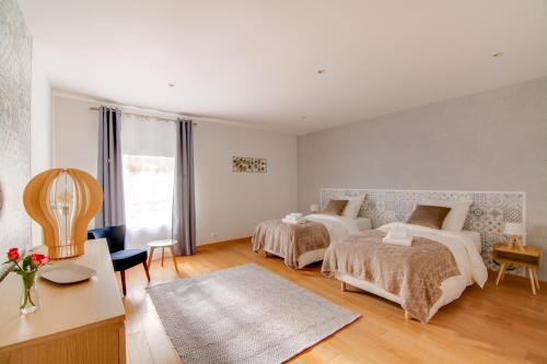 a bedroom with two beds and a table and a room at Maison d'hôtes La Villa des Ducs Bar-le-Duc in Bar-le-Duc