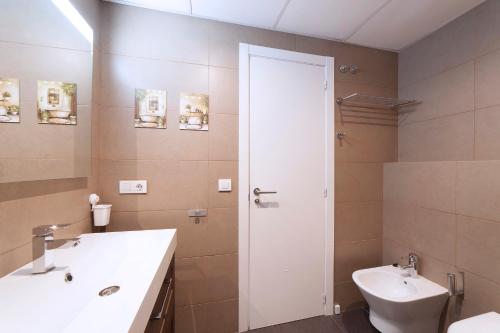 La salle de bains est pourvue d'un lavabo blanc et de toilettes. dans l'établissement Ático Valencia Centro, à Valence