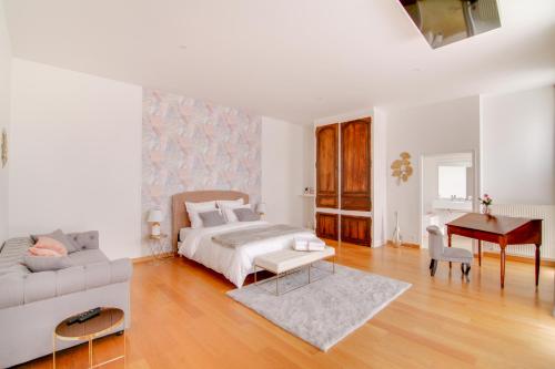 a bedroom with a bed and a couch and a table at Maison d'hôtes La Villa des Ducs Bar-le-Duc in Bar-le-Duc