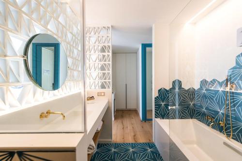 y baño con bañera y lavabo con espejo. en Boutique Hotel Villa Gala en Cadaqués