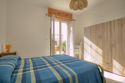 una camera con un letto con una coperta blu e gialla di Casa Nitti a Lido Marini