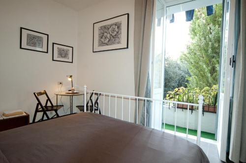 a bedroom with a bed and a balcony with a table at Light of Rome in Rome