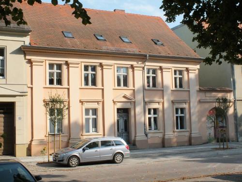 um carro prateado estacionado em frente a um edifício em Maisonette "im Alten Pfarrhaus" em Neuruppin