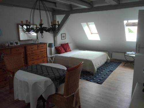 1 dormitorio con 2 camas, mesa y sillas en Maisonette "im Alten Pfarrhaus", en Neuruppin
