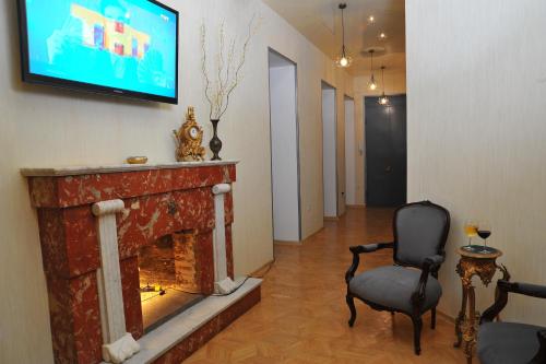 a living room with a fireplace and a tv on the wall at Brickwall Tbilisi-Tbilisi vibe in Tbilisi City