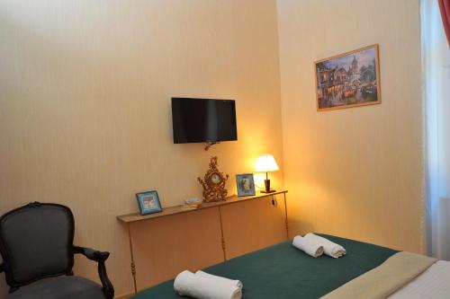 a room with a bed and a chair and a television at Brickwall Tbilisi-Tbilisi vibe in Tbilisi City