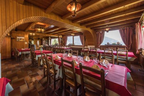 uma sala de jantar com mesas e cadeiras vermelhas em Les Sorbiers em Montricher-le-Bochet