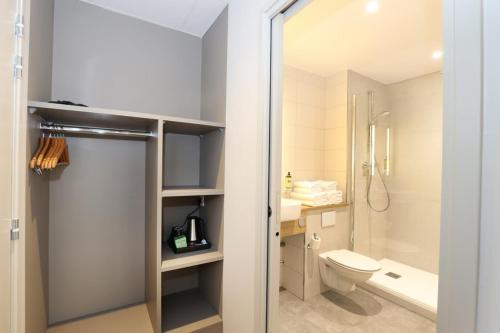 a bathroom with a toilet and a sink and a shower at Hôtel la Capelle Millau in Millau