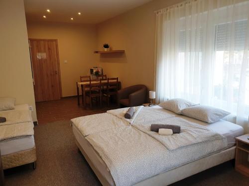 a bedroom with a large white bed and a window at Mediterrán Villa Kecskemét in Kecskemét