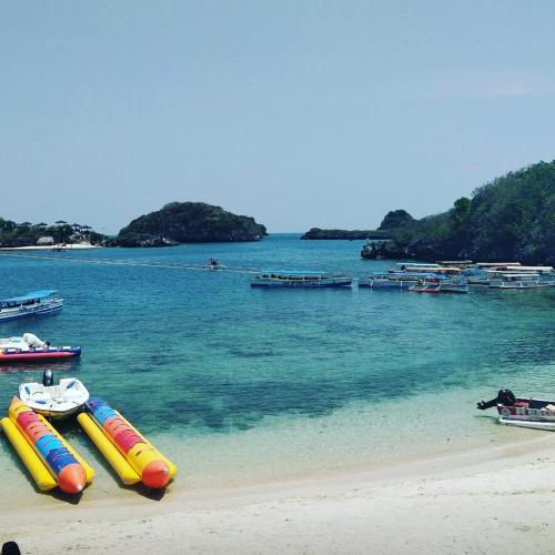 a beach with several inflatable boats in the water at Carribean Transient House in Lucap