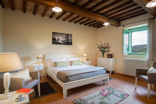 a bedroom with a bed and a chair and a window at Castello di Gallano Resort in Valtopina