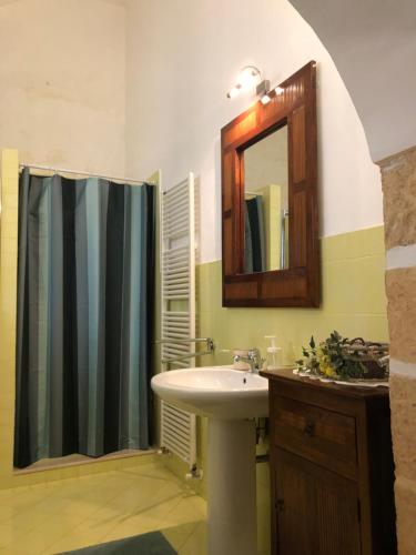 a bathroom with a sink and a shower curtain at Villa in Gargano - VILLA BASSO in Monte SantʼAngelo