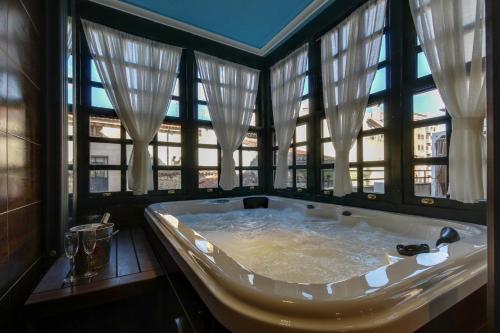 a large bath tub in a room with windows at Central Quality Apartment Spa Salamanca in Salamanca