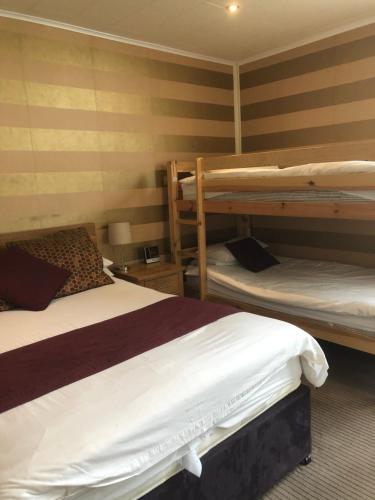 two beds in a room with two bunk beds at The Dog & Partridge Country Inn in Ashbourne