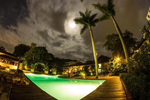 a pool at night with palm trees and lights at Hotel Museo Spa Casa Santo Domingo in Antigua Guatemala