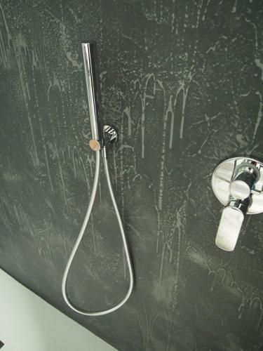 y baño con ducha y pared con graffiti. en CasaPi', en Torri del Benaco