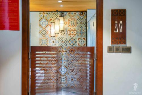 a wooden door with a decorative wall with a sign at Seahorse Han Market Da Nang Apartment by Haviland in Danang