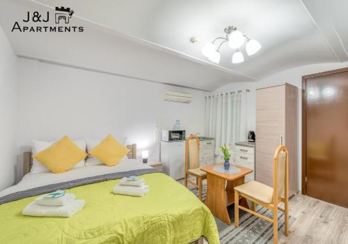 a bedroom with a bed and a table and a kitchen at J&J Apartments, Łazienna 30 Apartament 8/2 in Toruń