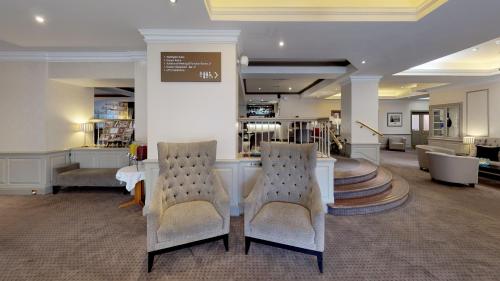 a living room filled with furniture and a large window at Bromley Court Hotel London in Bromley