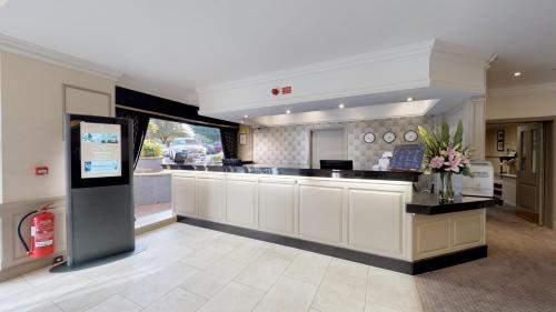 een grote keuken met witte kasten en een aanrecht bij Bromley Court Hotel London in Bromley