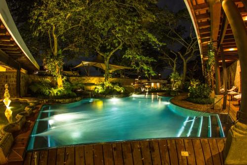a swimming pool with lights in a garden at night at Hotel Museo Spa Casa Santo Domingo in Antigua Guatemala